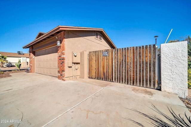 13051 N 75th Dr, Peoria, AZ 85381 - view of home's exterior featuring a gate, driveway, fence, a garage, and brick siding