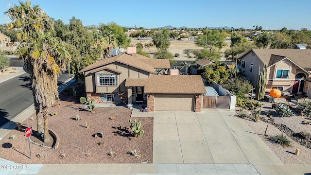 13051 N 75th Dr, Peoria, AZ 85381 - view of front of house with brick siding, concrete driveway, fence, an attached garage, and a shingled roof