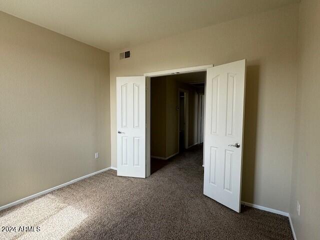 unfurnished bedroom featuring dark colored carpet