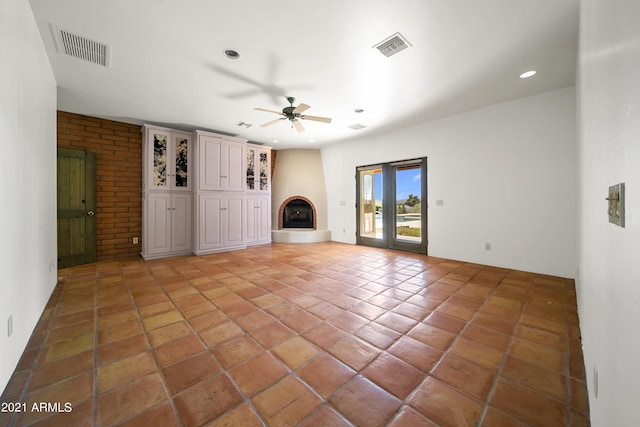 unfurnished living room with ceiling fan and a fireplace