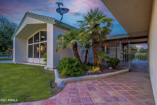 property exterior at dusk featuring a yard