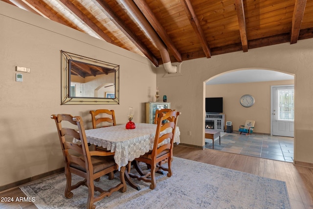 dining space featuring vaulted ceiling with beams, wood ceiling, and hardwood / wood-style flooring