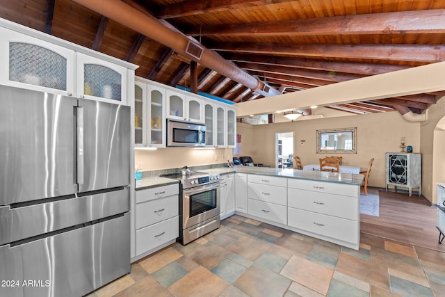 kitchen featuring appliances with stainless steel finishes, kitchen peninsula, and white cabinetry