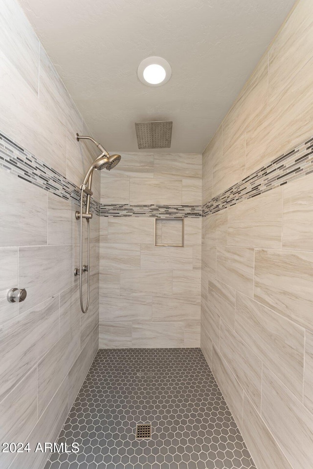 bathroom with tile patterned flooring and tiled shower