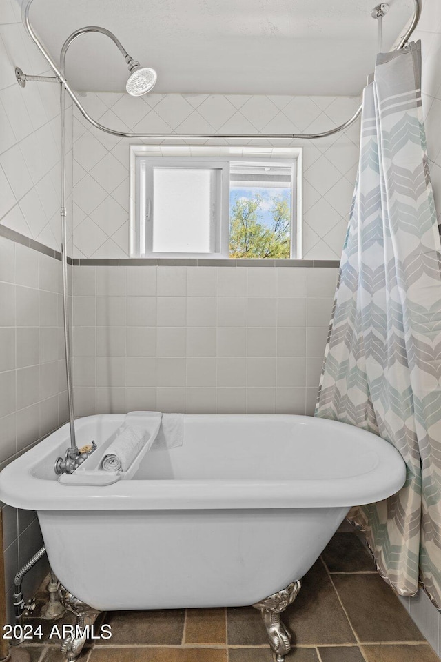 bathroom with tile walls, tile patterned flooring, and a washtub