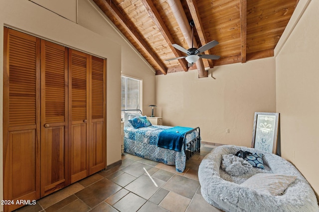 tiled bedroom featuring lofted ceiling with beams, wood ceiling, a closet, and ceiling fan