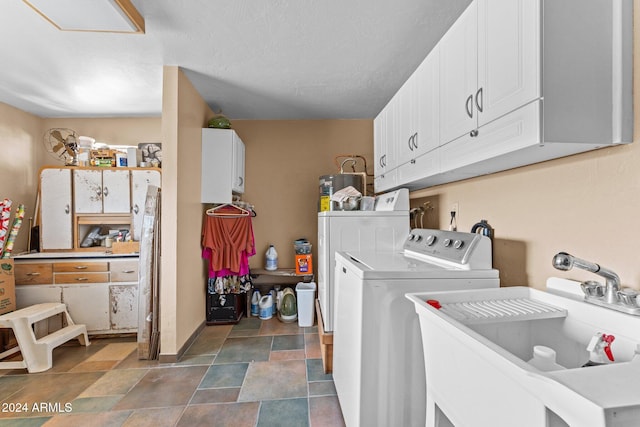 washroom featuring sink, independent washer and dryer, and cabinets