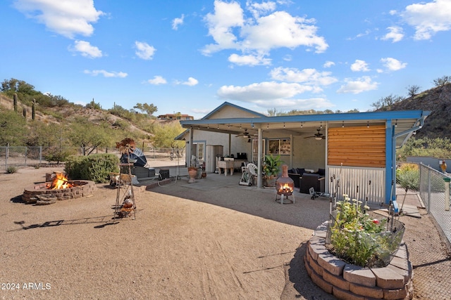 rear view of house featuring a patio, a fire pit, and ceiling fan