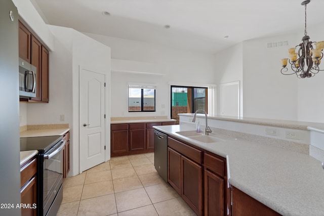 kitchen featuring appliances with stainless steel finishes, sink, pendant lighting, light tile patterned floors, and a notable chandelier