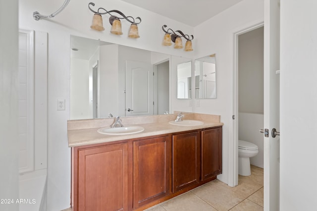 bathroom with toilet, double sink vanity, and tile patterned floors