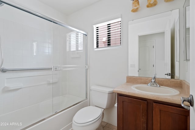 full bathroom featuring tile patterned flooring, enclosed tub / shower combo, vanity, and toilet