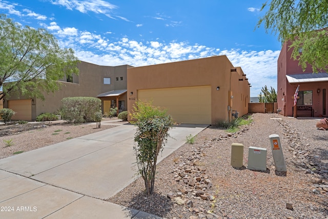 pueblo-style house featuring a garage