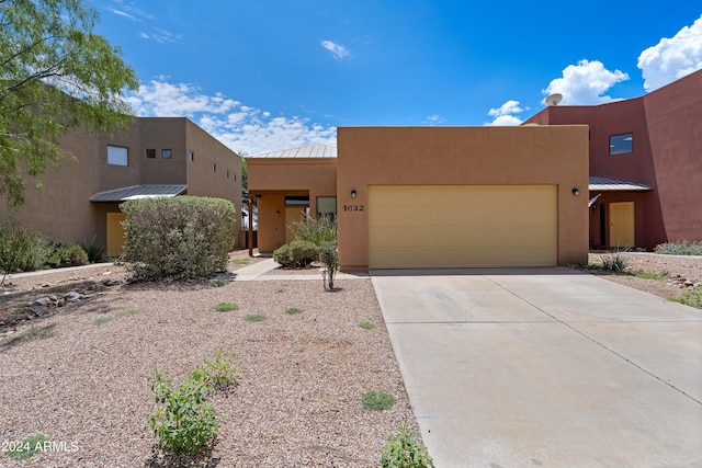 pueblo revival-style home with a garage