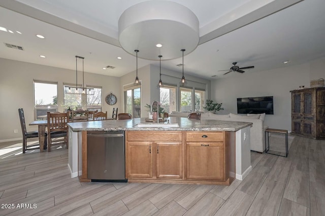 kitchen with visible vents, open floor plan, hanging light fixtures, dishwasher, and a center island with sink