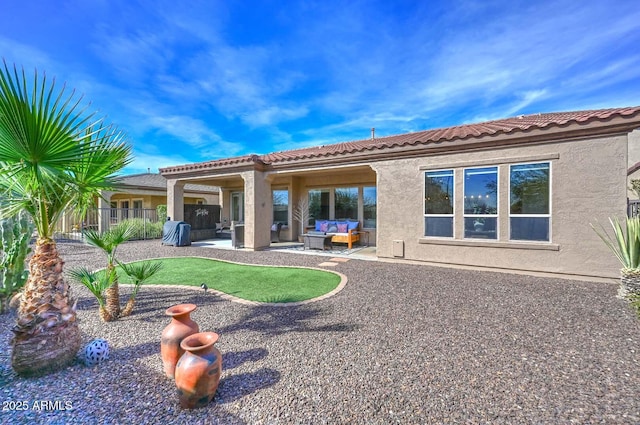 back of house with a tile roof, stucco siding, a patio area, and an outdoor hangout area