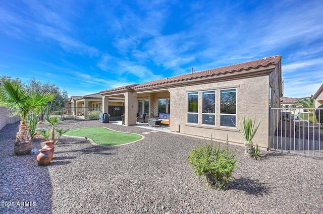 back of house featuring a fenced backyard, a tiled roof, a patio, and stucco siding