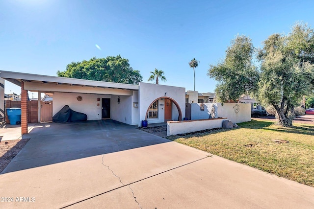 view of front of property featuring a front lawn and a carport