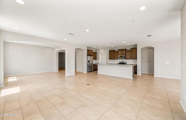 26949 W Lone Cactus Dr, Buckeye, AZ 85396 - unfurnished living room featuring arched walkways, light tile patterned flooring, recessed lighting, and baseboards
