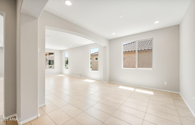 26949 W Lone Cactus Dr, Buckeye, AZ 85396 - unfurnished room featuring light tile patterned floors, arched walkways, recessed lighting, and baseboards