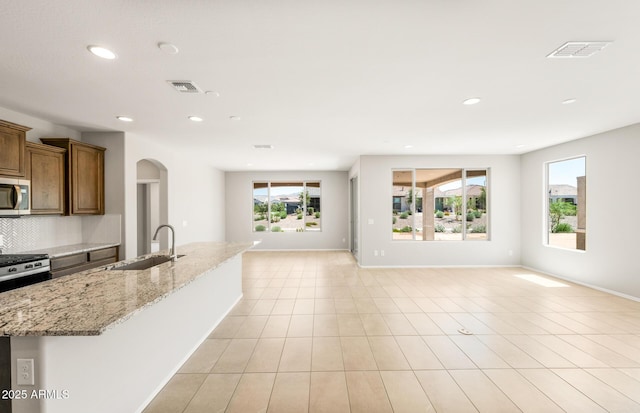 26949 W Lone Cactus Dr, Buckeye, AZ 85396 - kitchen with a sink, stainless steel appliances, open floor plan, arched walkways, and recessed lighting