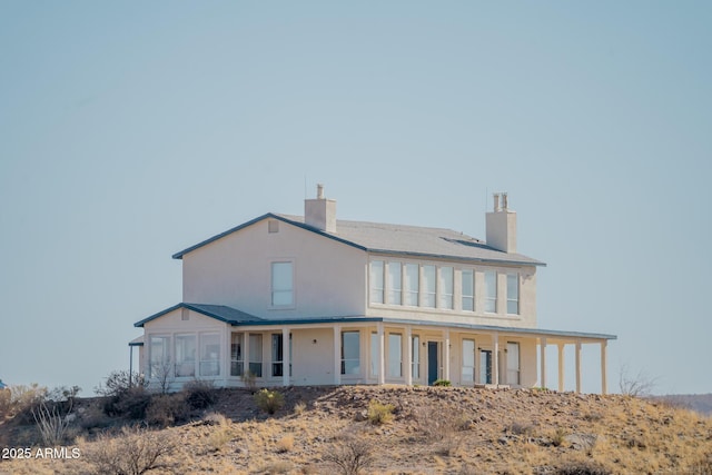 rear view of house featuring a chimney