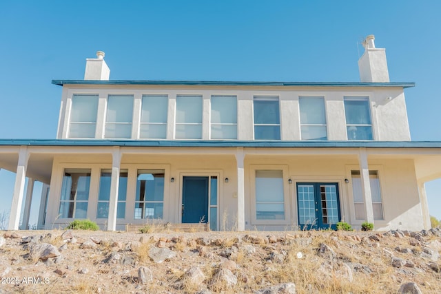 view of front of house with a chimney and stucco siding