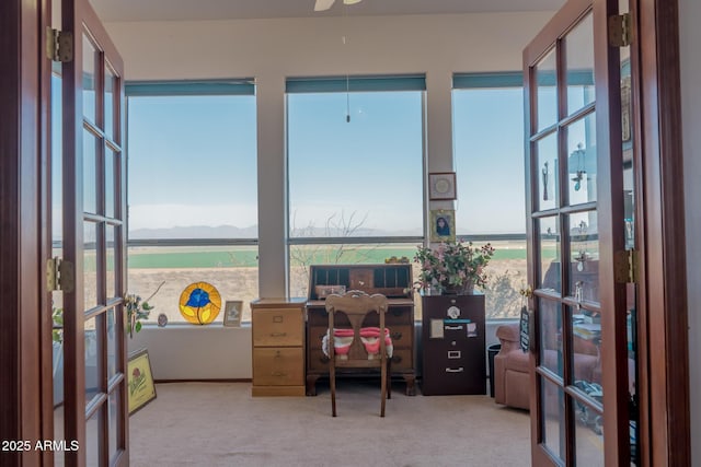 carpeted office with a wealth of natural light and french doors