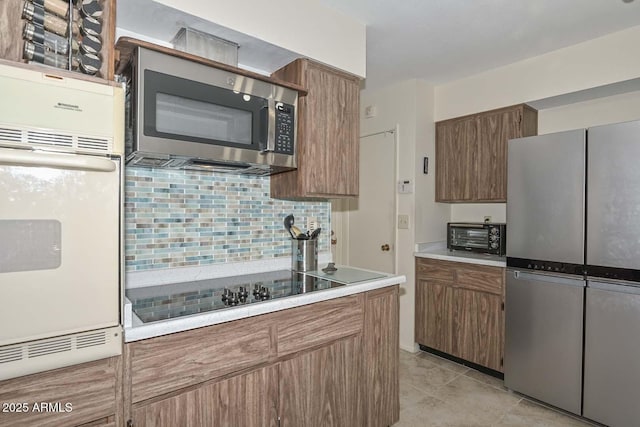 kitchen with appliances with stainless steel finishes and tasteful backsplash