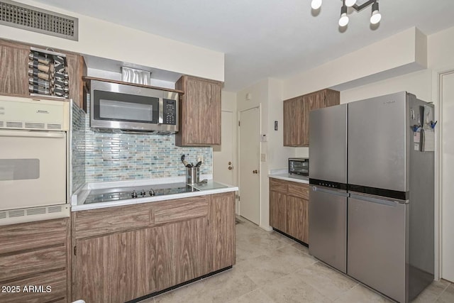 kitchen with appliances with stainless steel finishes and tasteful backsplash