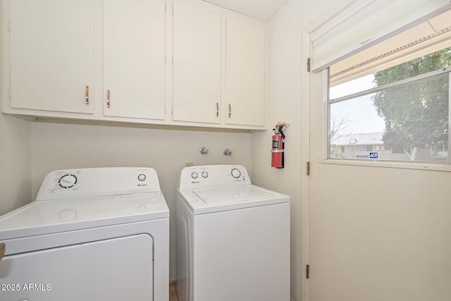 laundry room featuring washer and dryer and cabinets