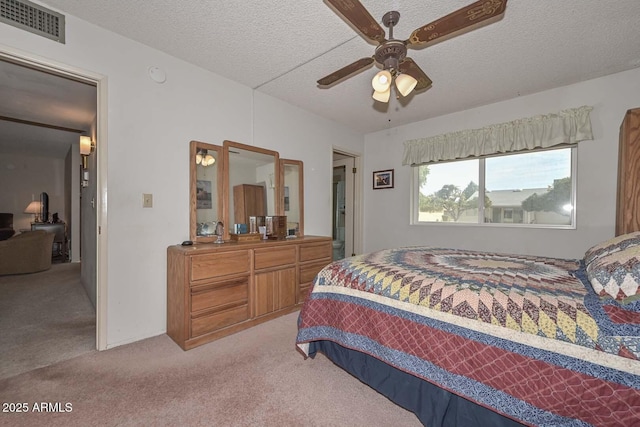 carpeted bedroom with ceiling fan and a textured ceiling