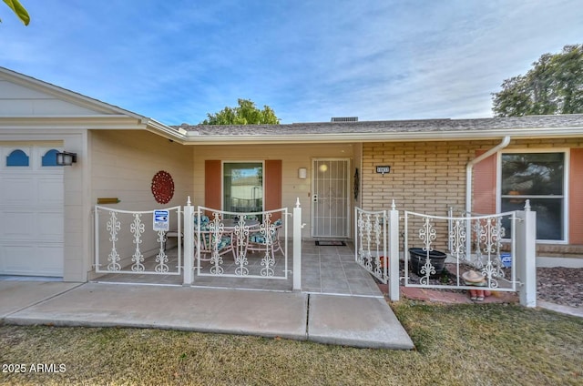 property entrance with a garage and a patio area