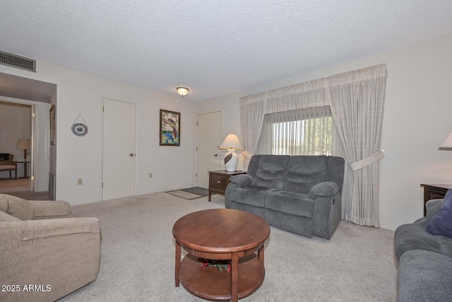 carpeted living room featuring a textured ceiling