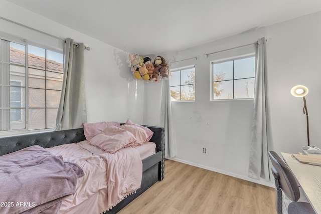 bedroom featuring multiple windows and light hardwood / wood-style flooring