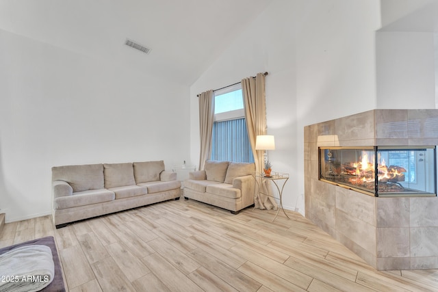 unfurnished living room featuring a fireplace and high vaulted ceiling