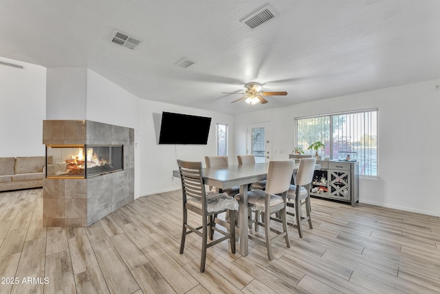 dining space featuring a fireplace and ceiling fan