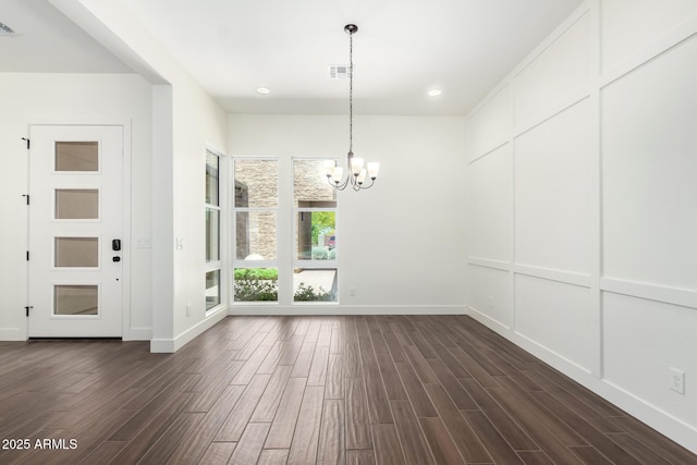 unfurnished dining area with dark wood-type flooring, visible vents, baseboards, and a notable chandelier