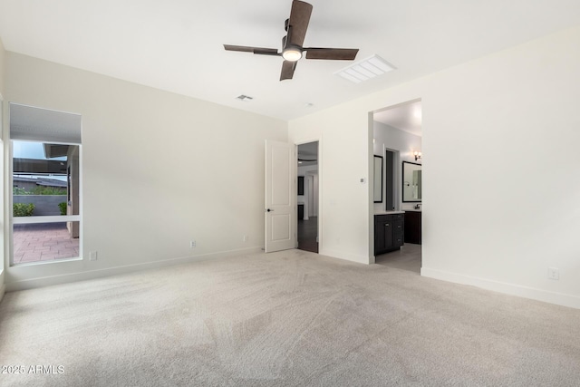 unfurnished bedroom with visible vents, light carpet, baseboards, and connected bathroom