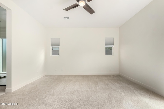 carpeted empty room with baseboards, visible vents, and ceiling fan