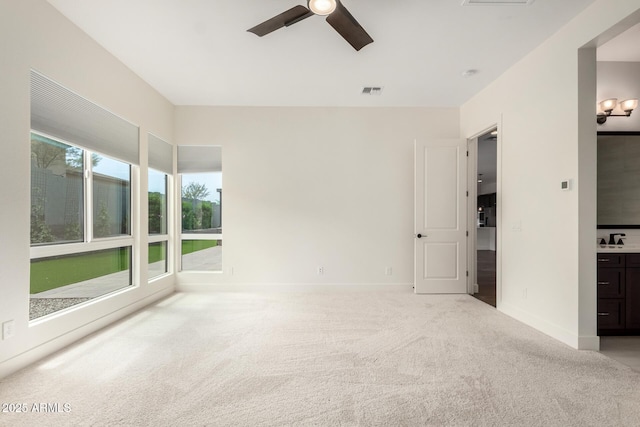 unfurnished bedroom with visible vents, a ceiling fan, a sink, baseboards, and carpet flooring