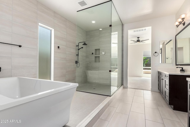 full bathroom with a freestanding bath, vanity, ceiling fan, a tile shower, and visible vents