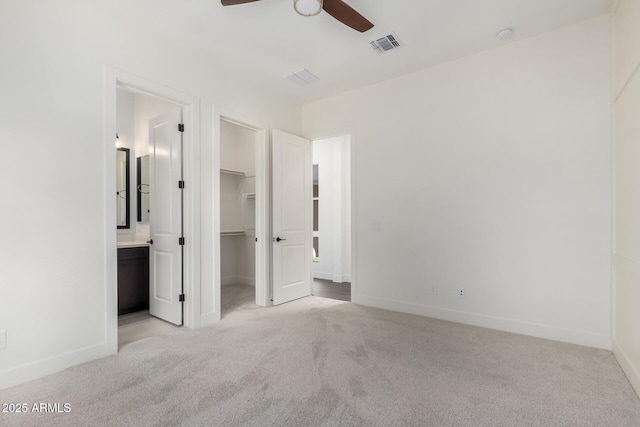 unfurnished bedroom featuring baseboards, a spacious closet, visible vents, carpet, and a closet