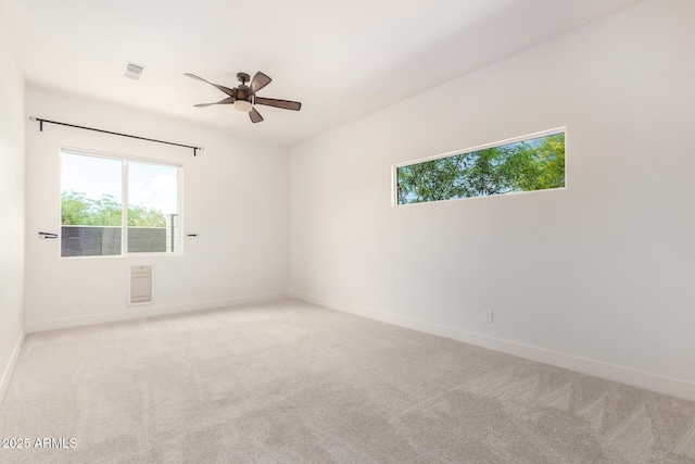 unfurnished room with light carpet, baseboards, visible vents, and ceiling fan