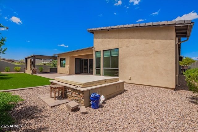 rear view of property with fence, a patio area, a yard, stucco siding, and a jacuzzi