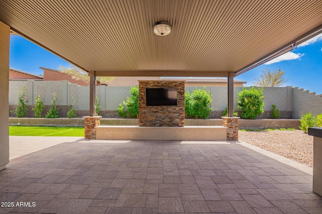 view of patio featuring a fenced backyard and an outdoor stone fireplace