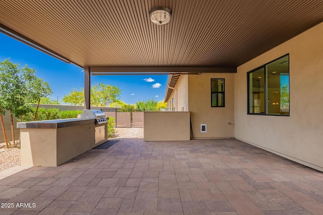 view of patio featuring an outdoor kitchen, fence, and area for grilling