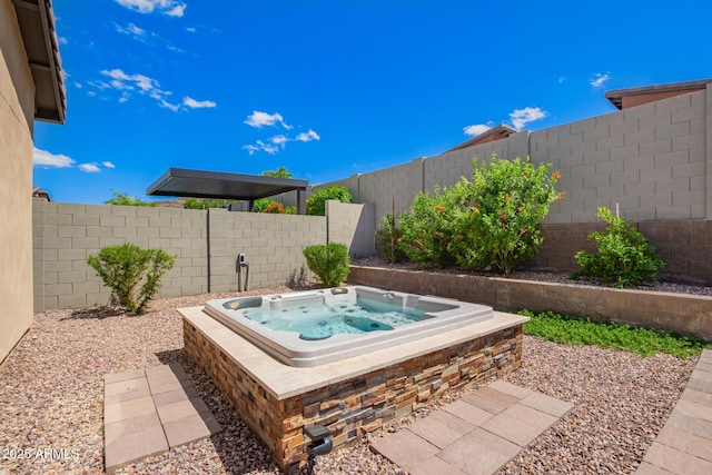 view of patio / terrace with a fenced backyard and an outdoor hot tub