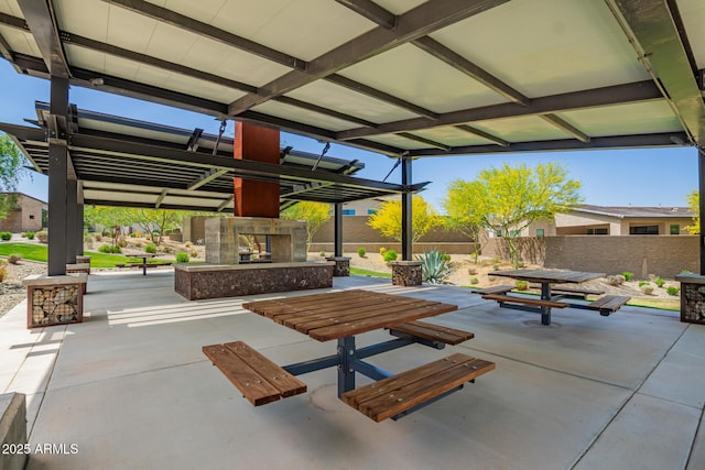 view of patio / terrace featuring an outdoor fireplace and a fenced backyard