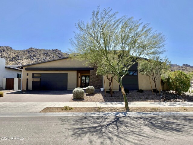 view of front of home featuring stucco siding, a mountain view, driveway, and a garage