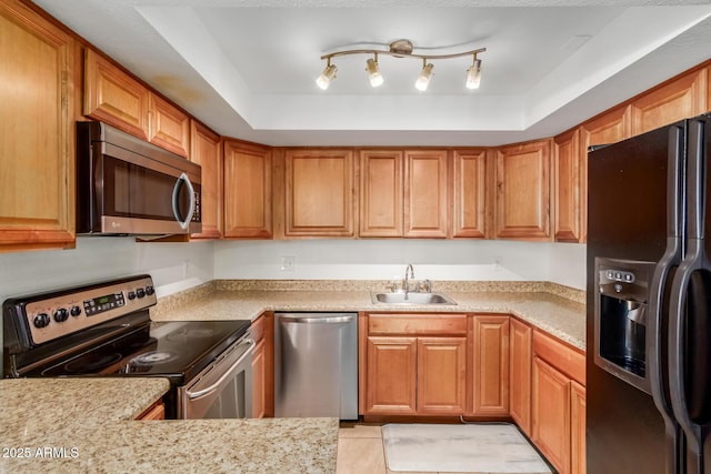 kitchen with appliances with stainless steel finishes, brown cabinetry, and a sink